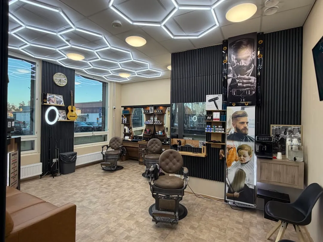 Parturi-kampaamo Salon La Cut Espoon Niittykummussa: tyylikäs asiakastila, jossa vintage-nahkatuolit ja moderni led-valaistus.